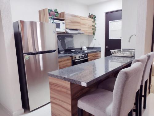 a kitchen with a stainless steel refrigerator and a counter at Love Vacations Tulum in Tulum