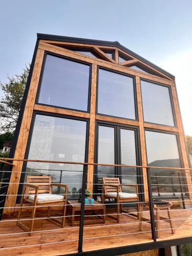 a house with glass windows and chairs on a deck at Mount Log Cabin in Mavrovo