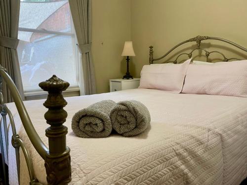 a bedroom with a bed with two pillows on it at Barnard street Cottage in Bendigo
