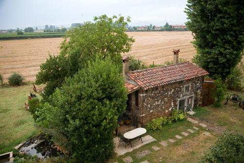a small stone house with a bench next to a field at Palazzetto Ardi in Torri di Confine