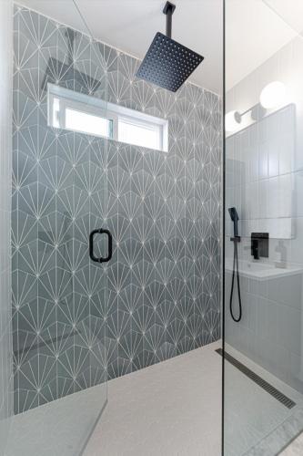a shower with a glass door in a bathroom at Chic Oasis Studio: Minutes to Downtown & Beaches in National City