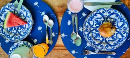 dos platos azules y blancos con fruta. en Pousada Jardon Ubatuba en Ubatuba