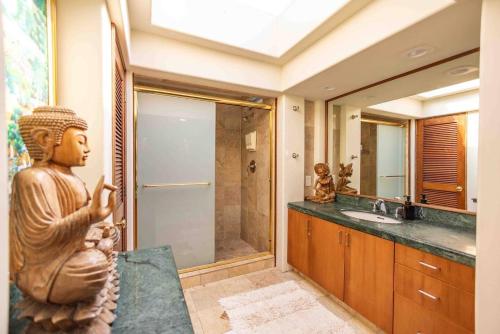 a bathroom with a statue of a woman on a counter at Jasmine Suite on Lush farm in Haiku, Maui jungle in Huelo