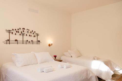 two beds in a room with white walls at Pousada Pouso de Laura in Tiradentes