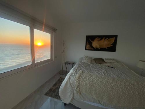 a bedroom with a bed and a large window at Lovely 2 bedroom oceanfront condo in Mazatlan in Mazatlán