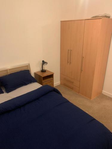 um quarto com uma cama e um armário de madeira em 2SWEETZ HOME 2 em Erith