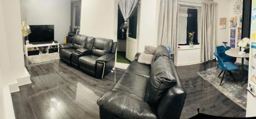 a living room with a leather couch and chairs at Cosy Room by Excel, Emirates Cable Car, 02Arena in London