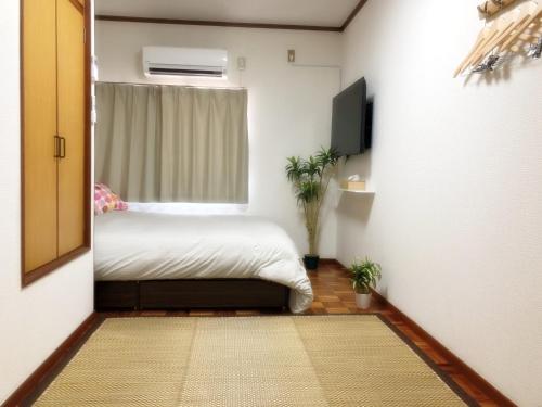 niewielka sypialnia z łóżkiem i oknem w obiekcie Nishikujo stay5 - Vacation STAY 14800 w Osace