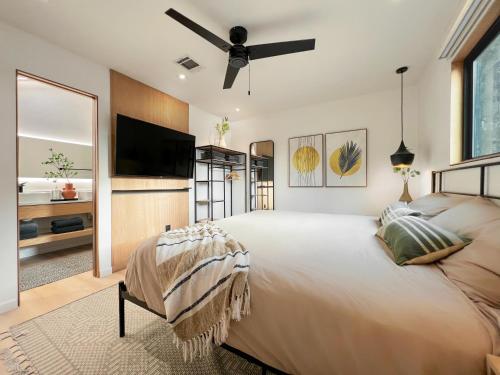 a bedroom with a large bed and a flat screen tv at 1_OAK - experience custom design - 2 masters in Houston