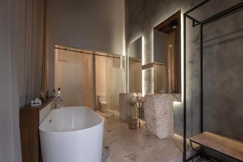 a large bathroom with a large tub and a sink at Piedra de Agua Merida in Mérida