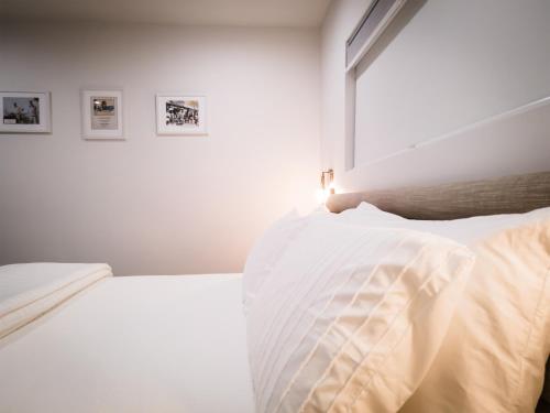 a white bedroom with two beds and a window at The Redline Venice in Los Angeles