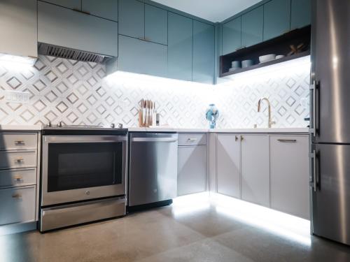 a kitchen with stainless steel appliances and blue cabinets at The Redline Venice in Los Angeles