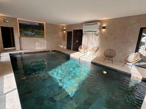 - une grande piscine d'eau bleue dans une maison dans l'établissement Lodge de luxe avec bain à remous, salle de sport, piscine, et options spa et golf - FR-1-582-381, au Chambon-sur-Lignon