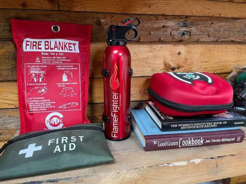 a red fire extinguisher sitting on top of books at Maple tree lodge. Quirky handcrafted Irish cabin in Dromara