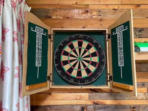 a dart board sitting on top of a wooden wall at Maple tree lodge. Quirky handcrafted Irish cabin in Dromara