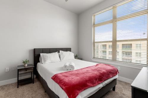 um quarto com uma cama grande e um cobertor vermelho em The Olivia: Riverwalk Loft em San Antonio