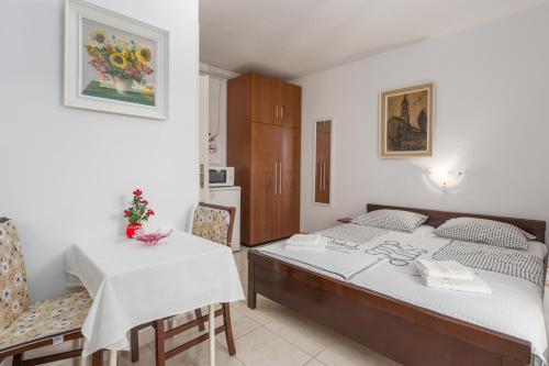 a bedroom with a bed and a table and chairs at Apartments with a parking space Tar, Porec - 6948 in Tar