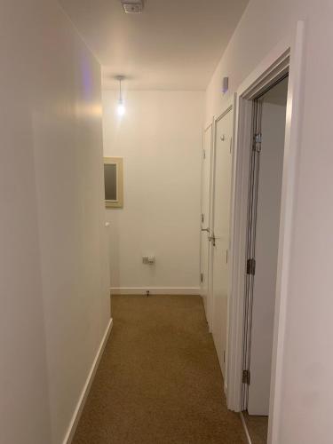 um corredor vazio com paredes brancas e uma porta em 2SWEETZ HOME 2 em Erith
