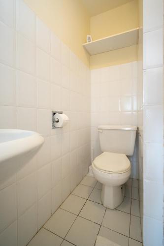 a white bathroom with a toilet and a sink at Studio Mrljane 327b in Neviđane