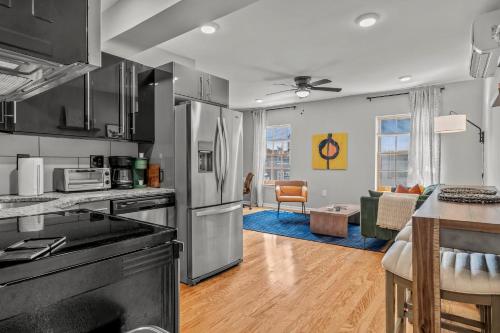 a kitchen with stainless steel appliances and a living room at Stay Rafa At 259 in Philadelphia