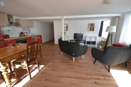 eine Küche und ein Wohnzimmer mit einem Tisch und Stühlen in der Unterkunft Bachperle in Steckborn