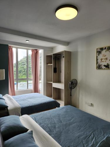 a bedroom with two beds and a window at Camping Styles 2 Emerald Avenue Cameron Highlands 10Pax 821 Wifi in Brinchang