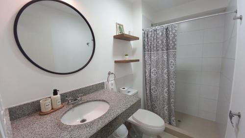uma casa de banho com um lavatório, um espelho e um WC. em Moderno y acogedor cerca al mar em Lima