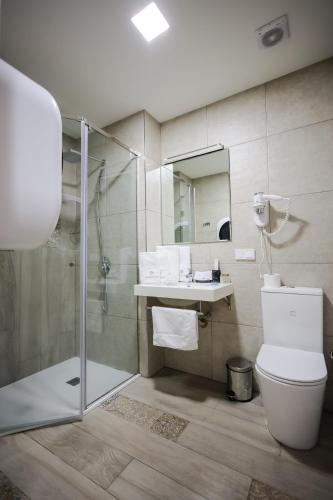 a bathroom with a shower and a toilet and a sink at Rooftop Apart-Hotel in Yerevan