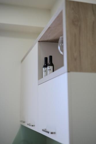 two bottles of wine in a cabinet in a kitchen at Rooftop Apart-Hotel in Yerevan