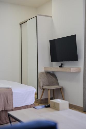 a room with a bed and a desk with a television at Rooftop Apart-Hotel in Yerevan