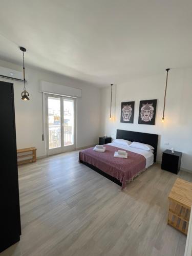 una grande camera da letto con un letto e un pavimento in legno di {Palazzo Fodale-5 stelle} APARTMENT 70’s ROOMS a Trapani