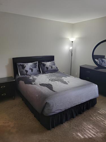 a bedroom with a bed and a mirror on the wall at Serenity Apartment in Chesterfield