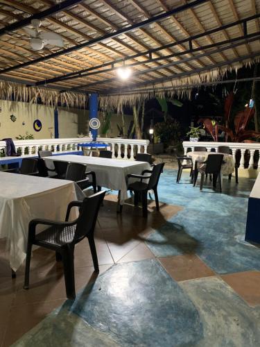 um restaurante com mesas e cadeiras brancas num quarto em AO EO little wooden house honeymoon suite em Santiago de los Caballeros