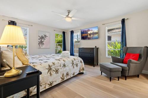 a bedroom with a bed and a desk and a chair at Boaters Bayshore Bungalow in Naples