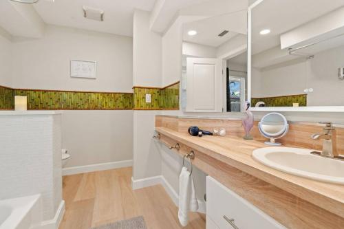 a bathroom with a sink and a mirror at Boaters Bayshore Bungalow in Naples