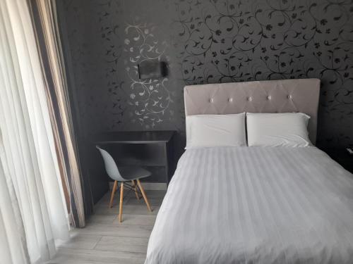 1 dormitorio con cama, silla y escritorio en hotel taymi en Trujillo