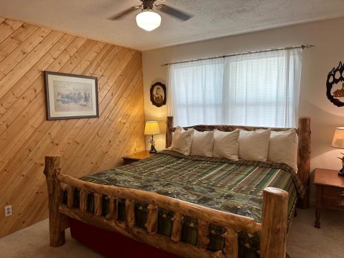 una camera da letto con un letto in una stanza con pareti in legno di Long Shot Cabin a Red River
