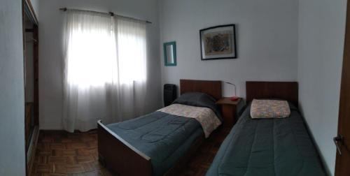 1 dormitorio con 2 camas y ventana en Casa/ Villa General Belgrano en Villa General Belgrano