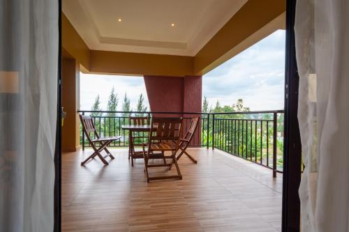 a balcony with chairs and a table with a view at Las Vegas Garden Hotel Mbarara in Mbarara