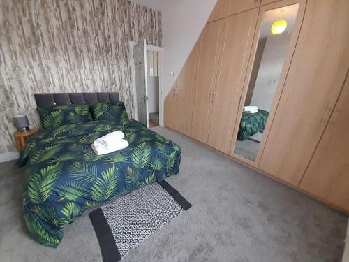 ビショップ・オークランドにあるFabulous Holiday Home - sleeps 6のベッドルーム(ベッド1台、大きな鏡付)