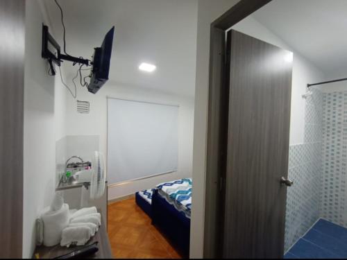 baño con espejo y cama en una habitación en CASA HOTEL QR, en Cali