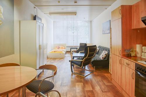 eine Küche und ein Wohnzimmer mit Tisch und Stühlen in der Unterkunft Schlafen in Rosengarten in Rosengarten