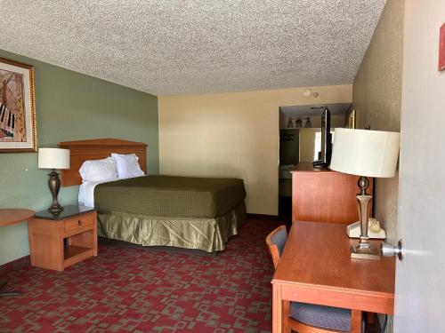 a small hotel room with a bed and a desk at Gateway Lodge in Rifle