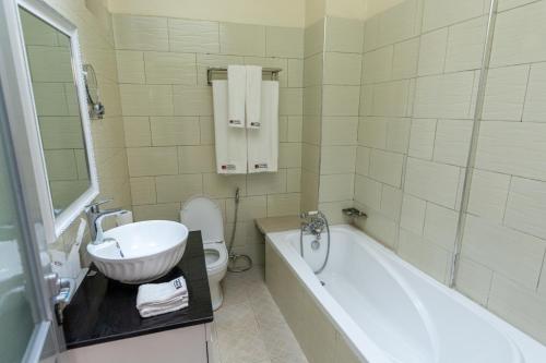 a bathroom with a sink and a toilet and a tub at Las Vegas Garden Hotel Mbarara in Mbarara
