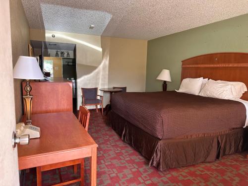a hotel room with a bed and a table with a telephone at Gateway Lodge in Rifle