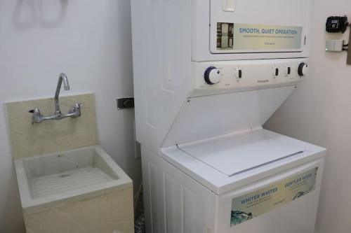 eine Küche mit Spüle, Waschmaschine und Trockner in der Unterkunft 24o Penthouse Unique Design 2 Balconies Oceanview in ArraijÃ¡n