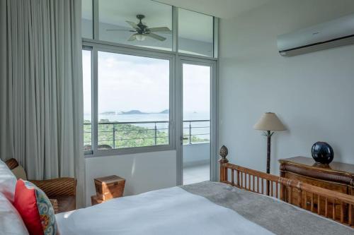 a bedroom with a bed and a large window at 24o Penthouse Unique Design 2 Balconies Oceanview in ArraijÃ¡n