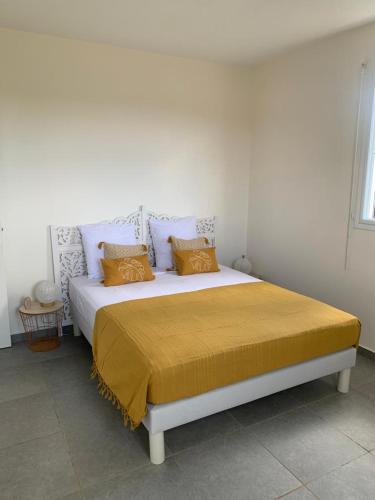 ein Schlafzimmer mit einem großen Bett und einer gelben Decke in der Unterkunft Villa rubis in Saint-François