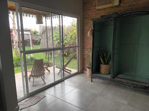 een afgeschermde veranda met een stoel en glazen schuifdeuren bij Casa amplia en Resistencia in Resistencia