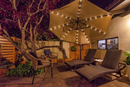 a patio with chairs and an umbrella with lights at Silverado Golf Course View Property in Napa